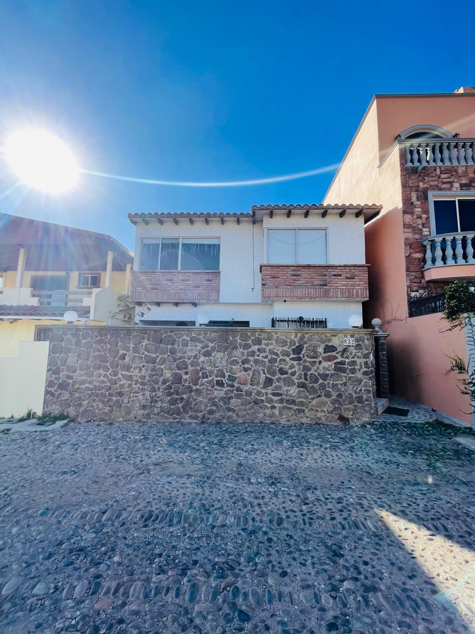 Fachada de la residencia con muro de piedra volcánica y acceso principal
